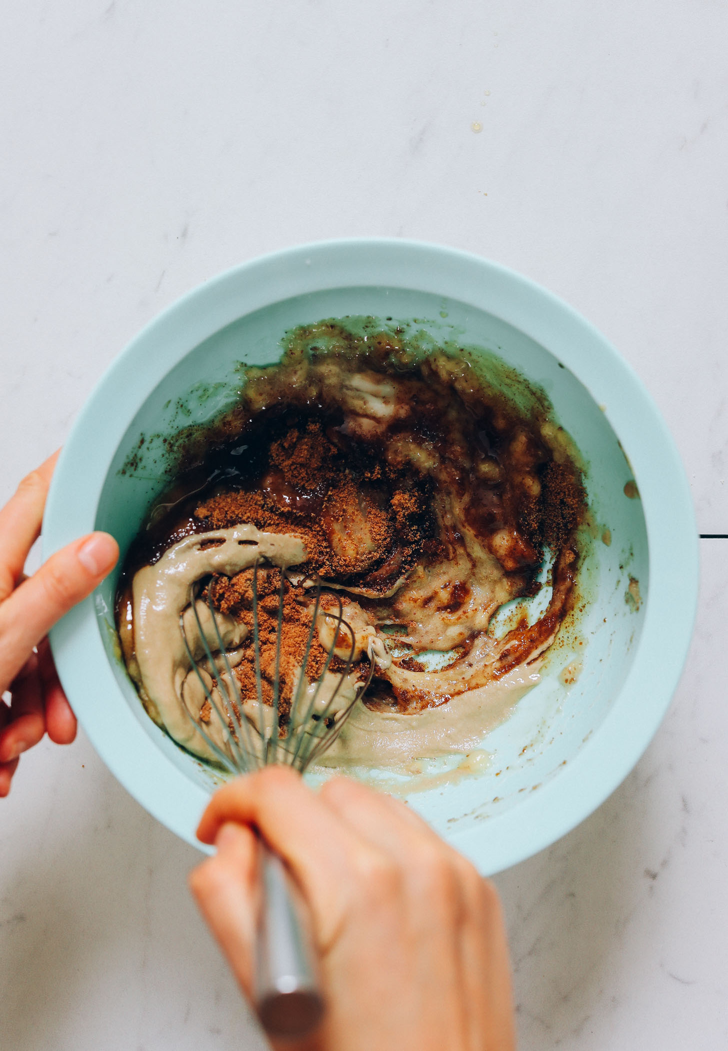 Using a whisk to stir together wet ingredients for our Banana Chocolate Muffins recipe