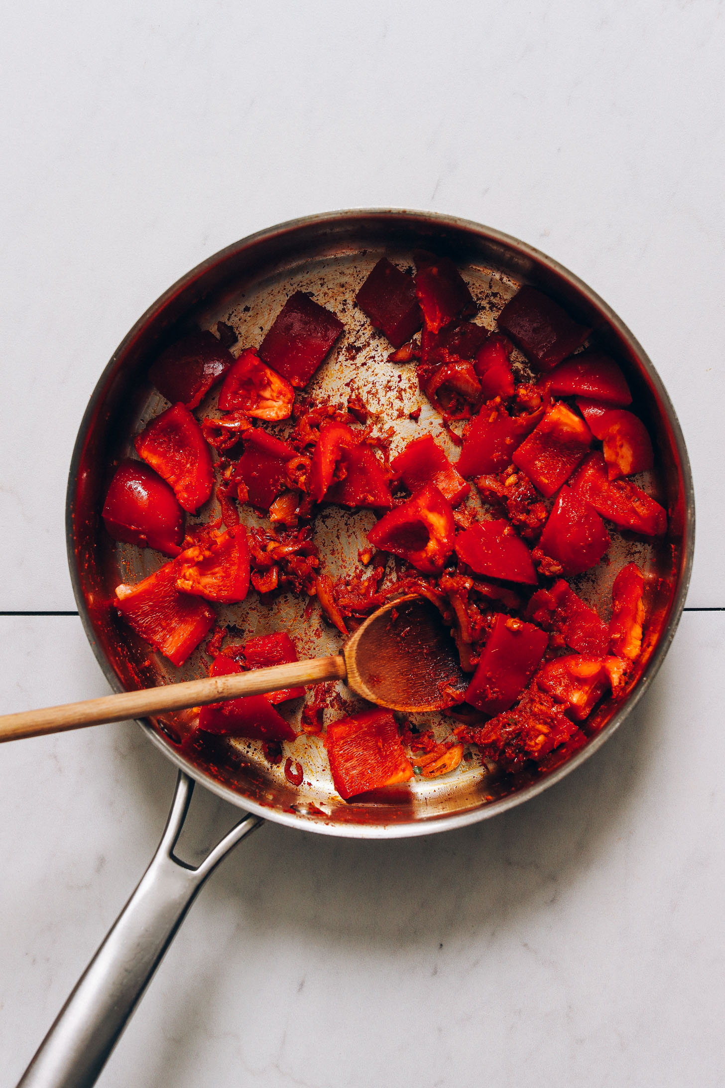 Skillet of sliced bell pepper, shallot, red curry paste, and other ingredients