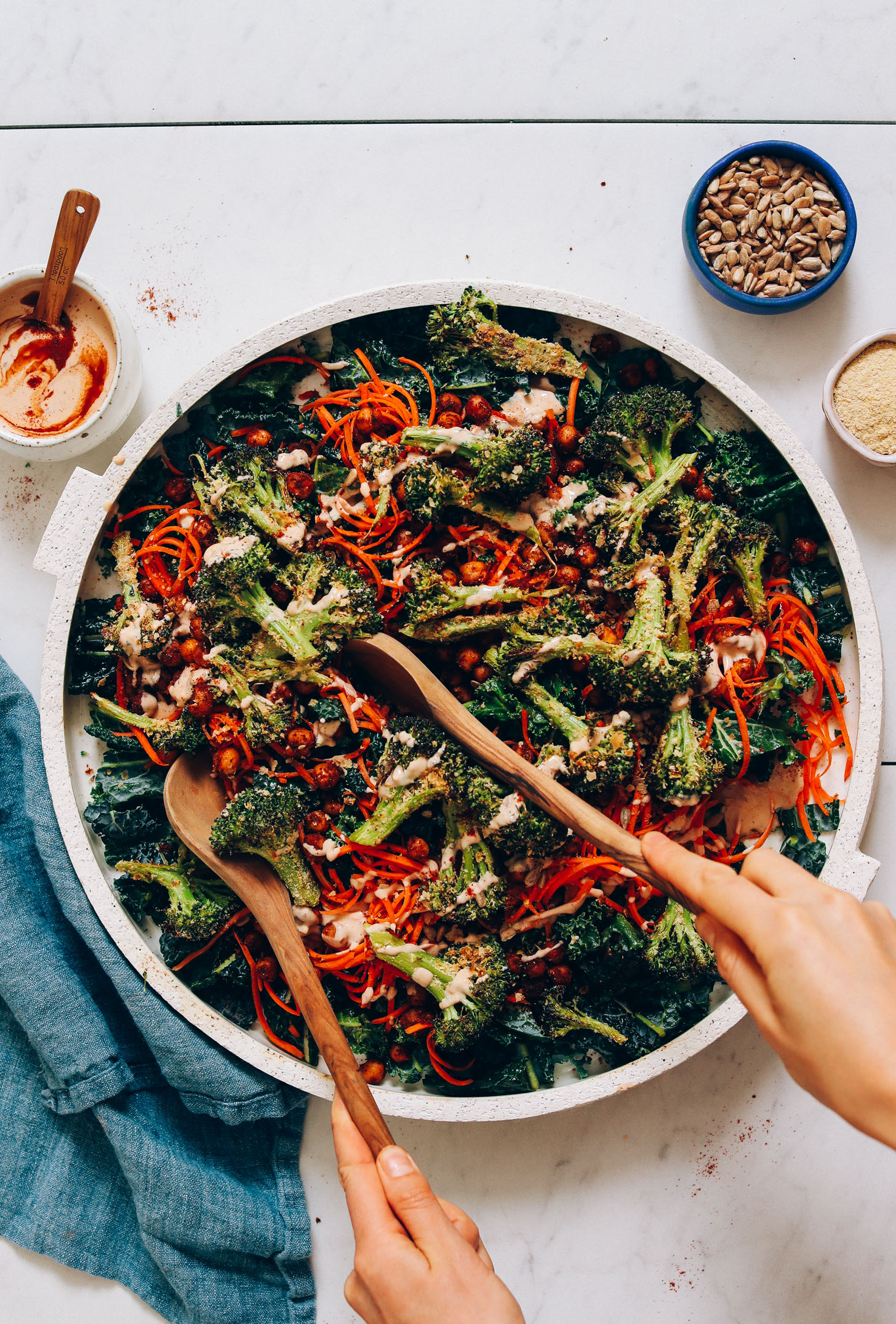 Using wooden salad spoons to pick up a serving of Cheesy Roasted Broccoli Salad
