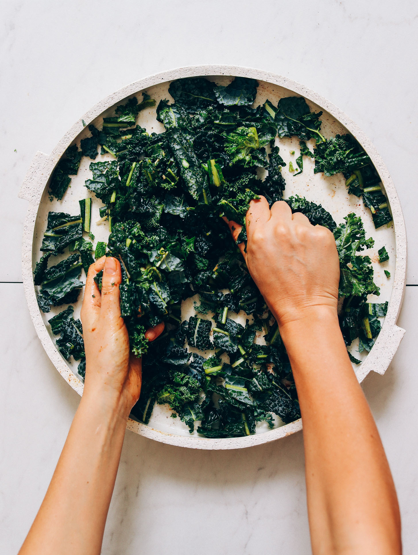 Massaging lacinato kale on a platter