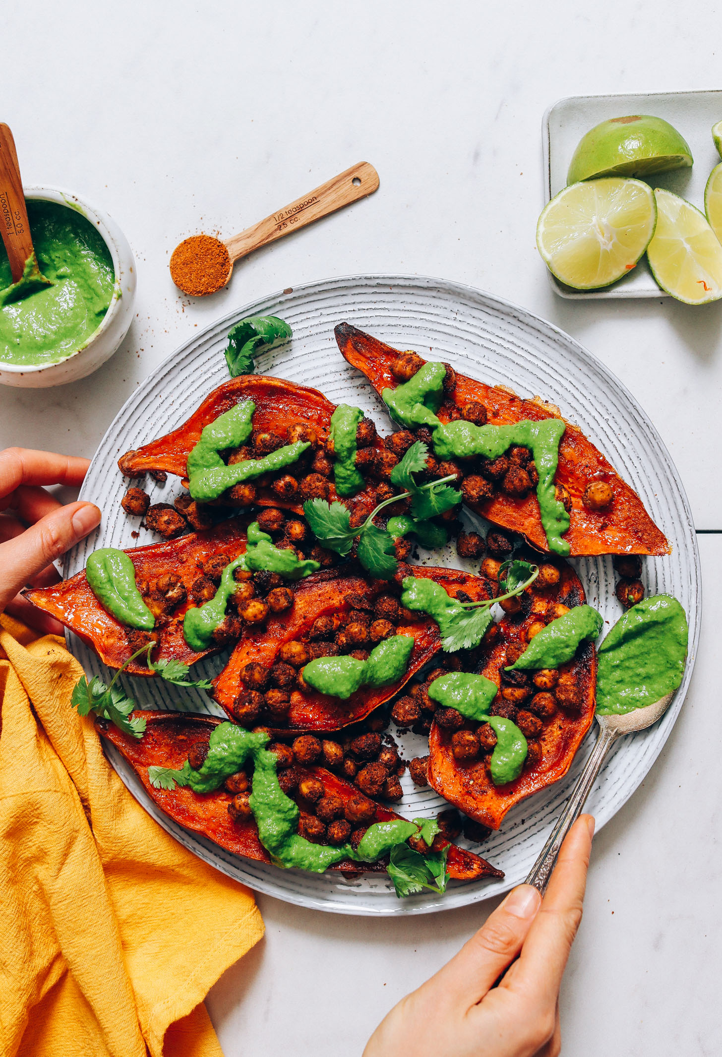 Plate of vegan Masala Chickpea Stuffed Sweet Potatoes with green chutney