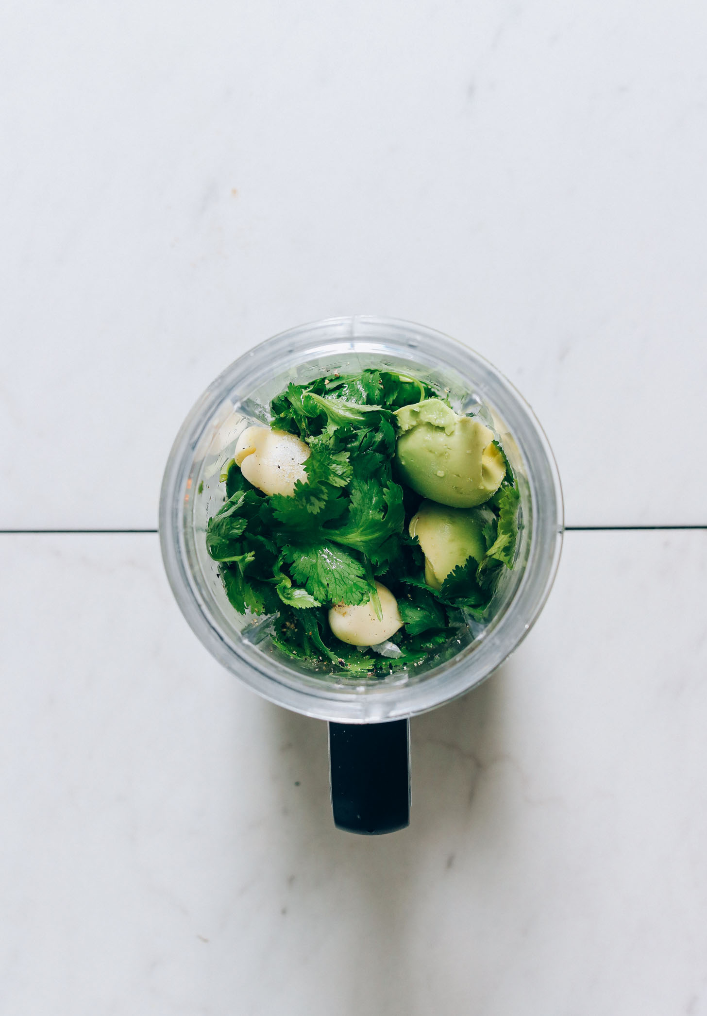 Cilantro, garlic, salt, pepper, and avocado in a small blender