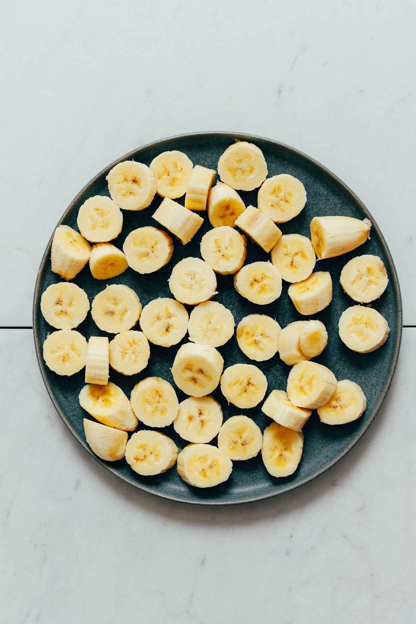 Plate of sliced banana chunks for adding to the freezer for Banana Nice Cream