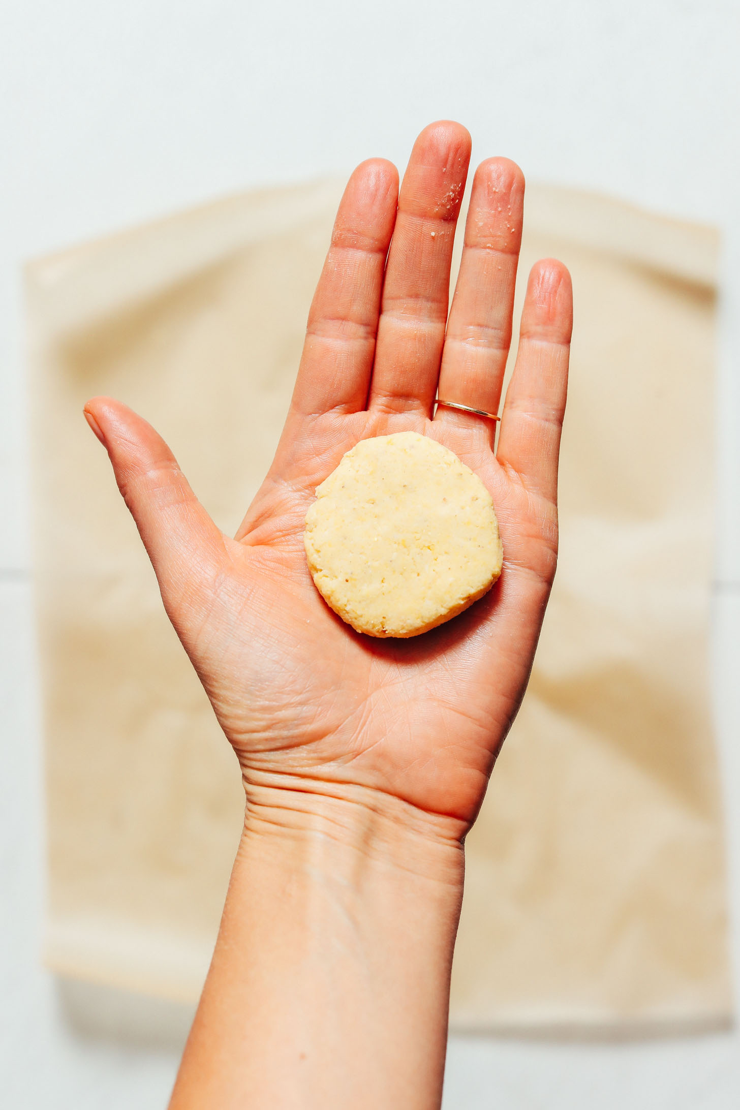 Holding a circle of corn tortilla dough for our tutorial on How to Make Tortillas