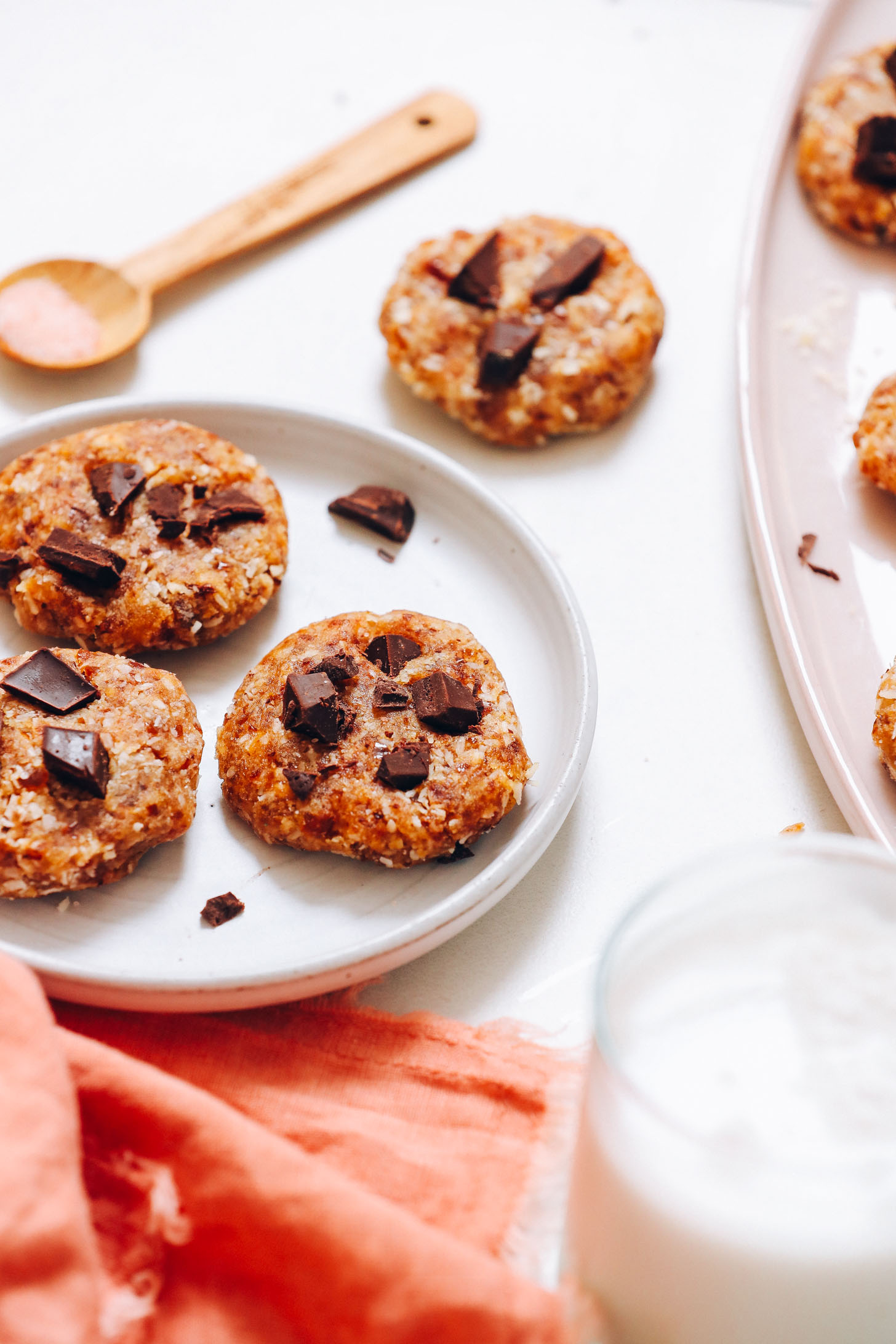 Plate and platter of gluten-free no-bake cookies next to a glass of dairy-free milk