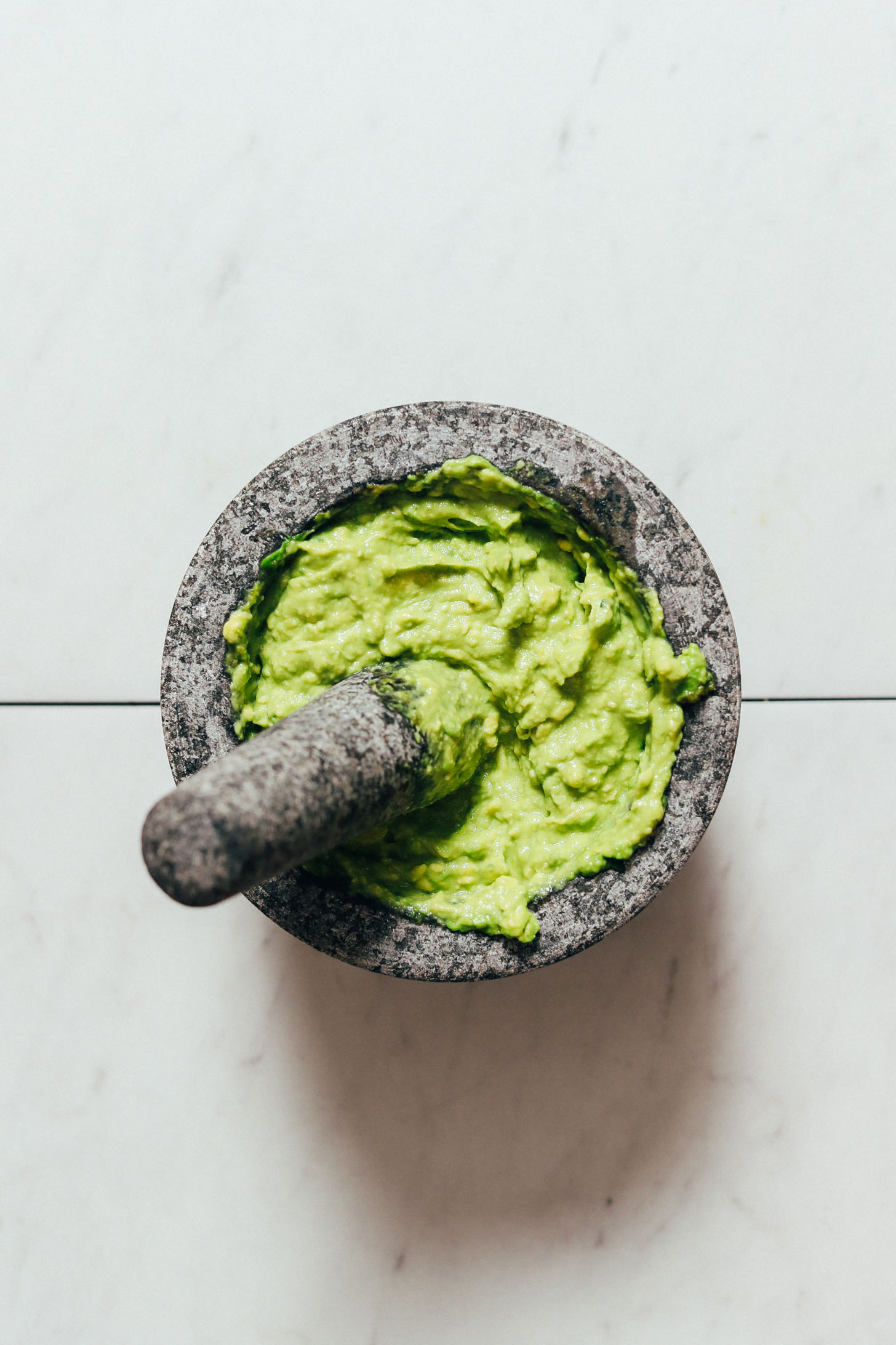 Creamy Rosemary & Serrano Guacamole in a mortar and pestle