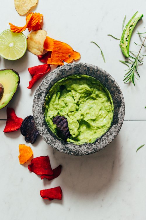 Chip in a mortar and pestle of Serrano & Rosemary Guacamole