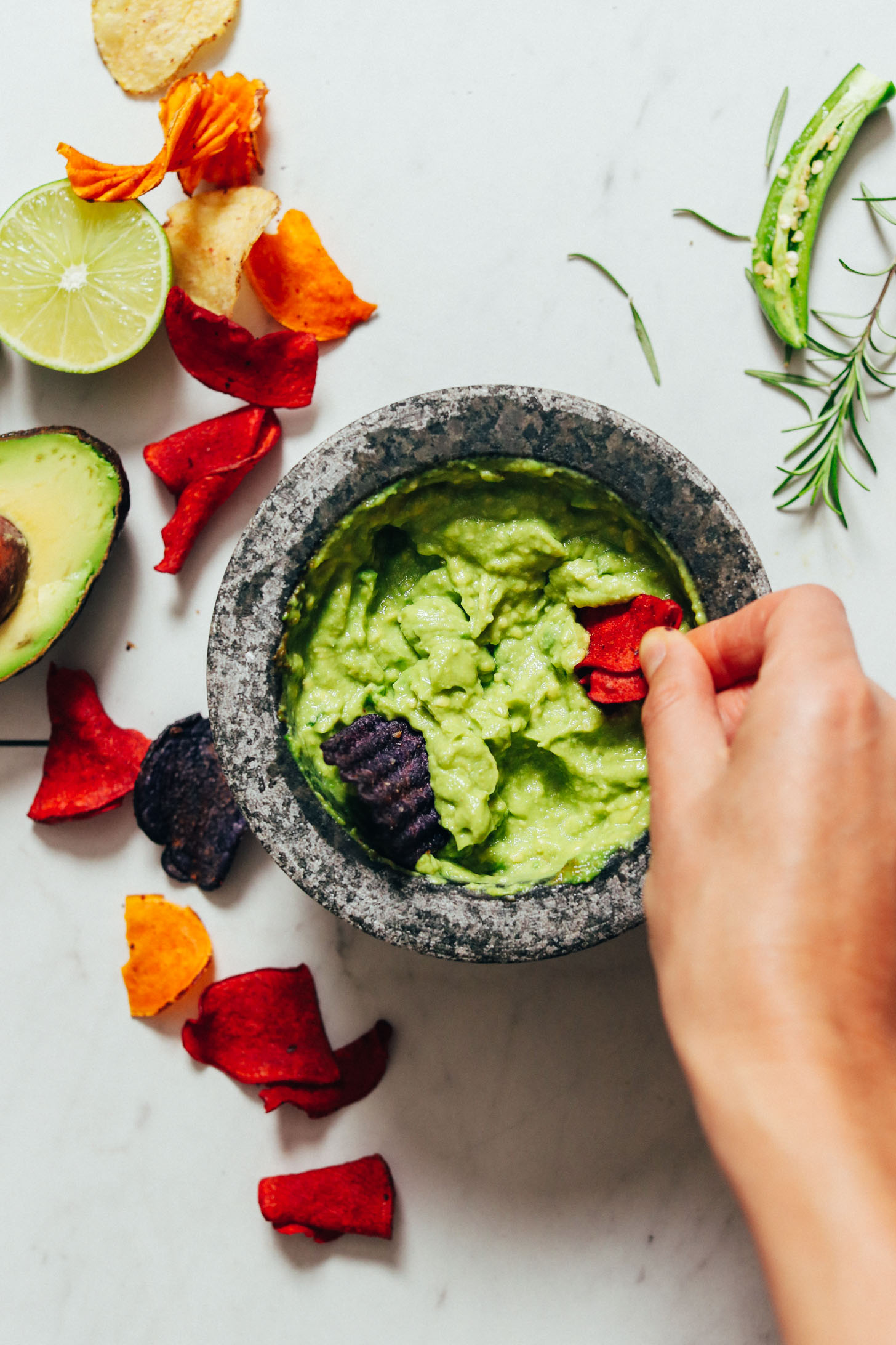 Using a chip to scoop up a bite of Rosemary and Serrano Guacamole