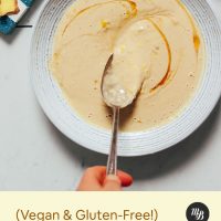 Spoon lifting a serving of Lemony Ginger Tahini Sauce