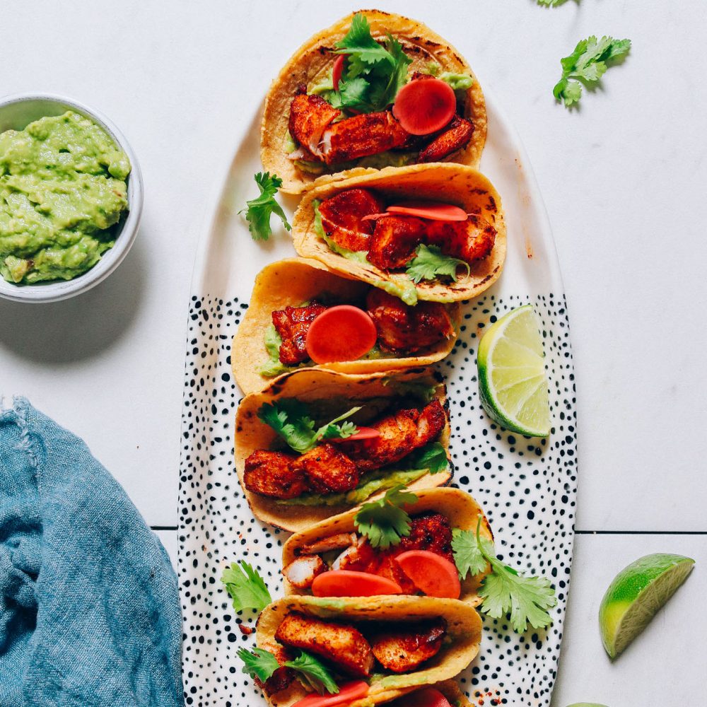 Platter of Spicy Baked Fish Tacos with limes and guacamole