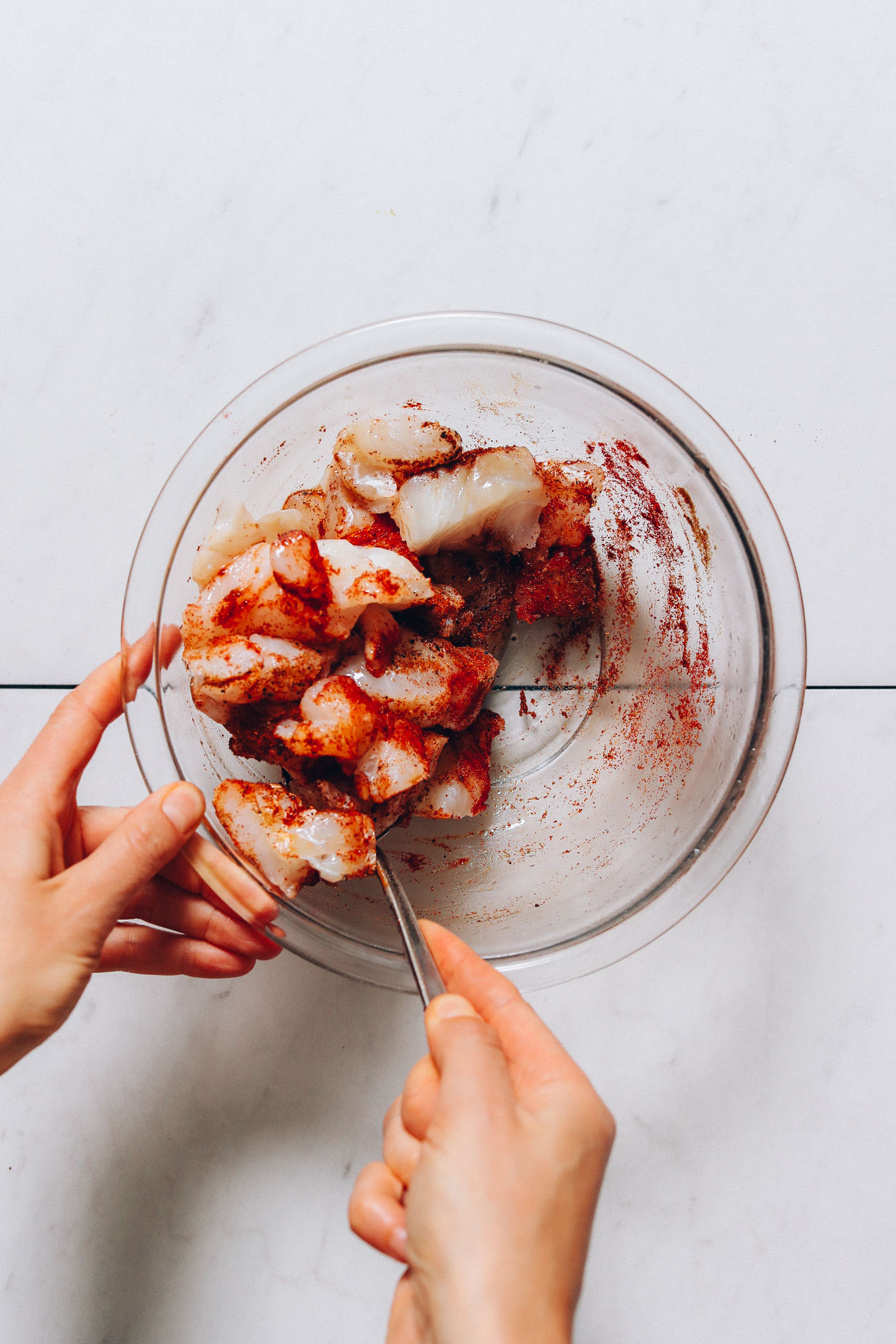 Mixing pieces of cod with spices for our Spicy Fish Tacos recipe