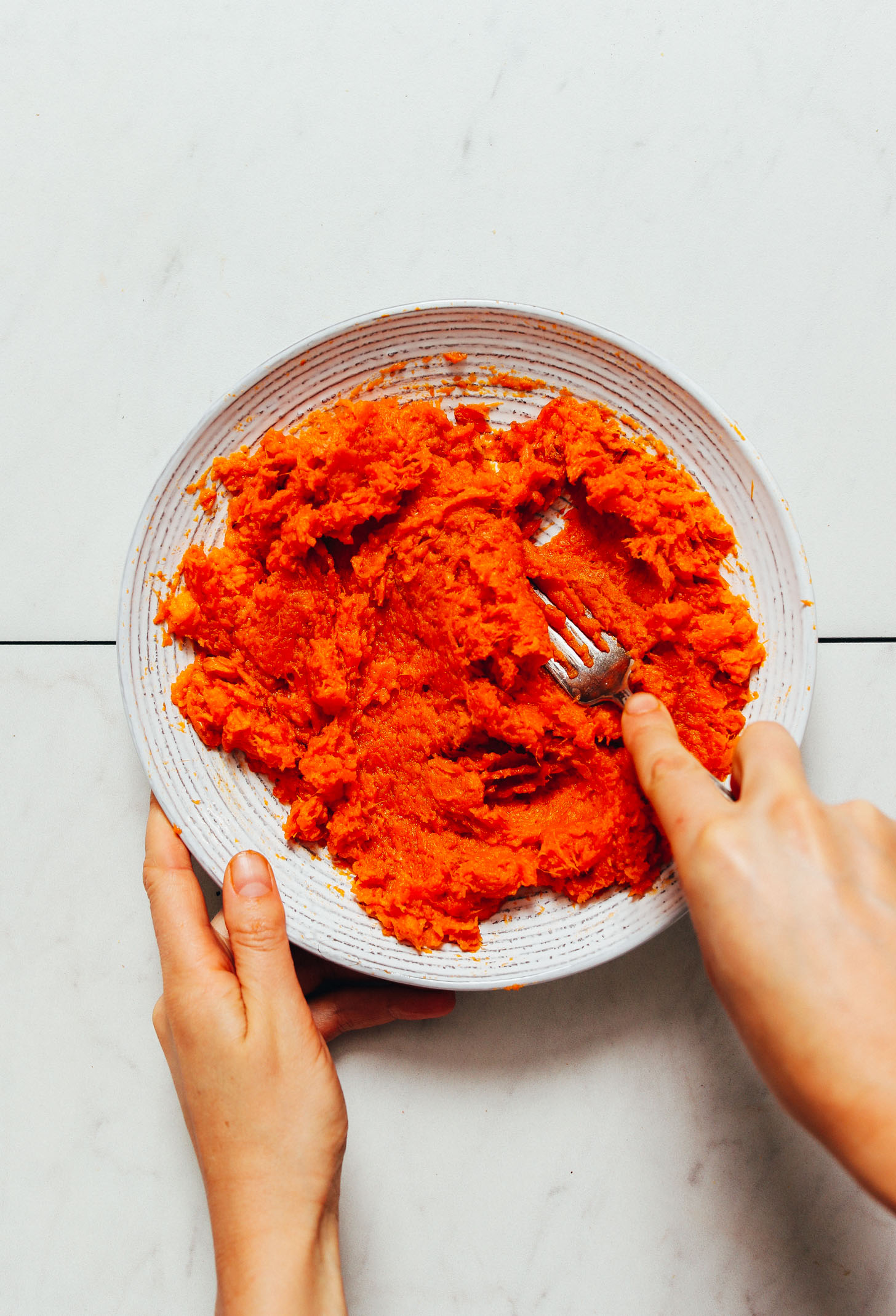 Using a fork to mash roasted sweet potato