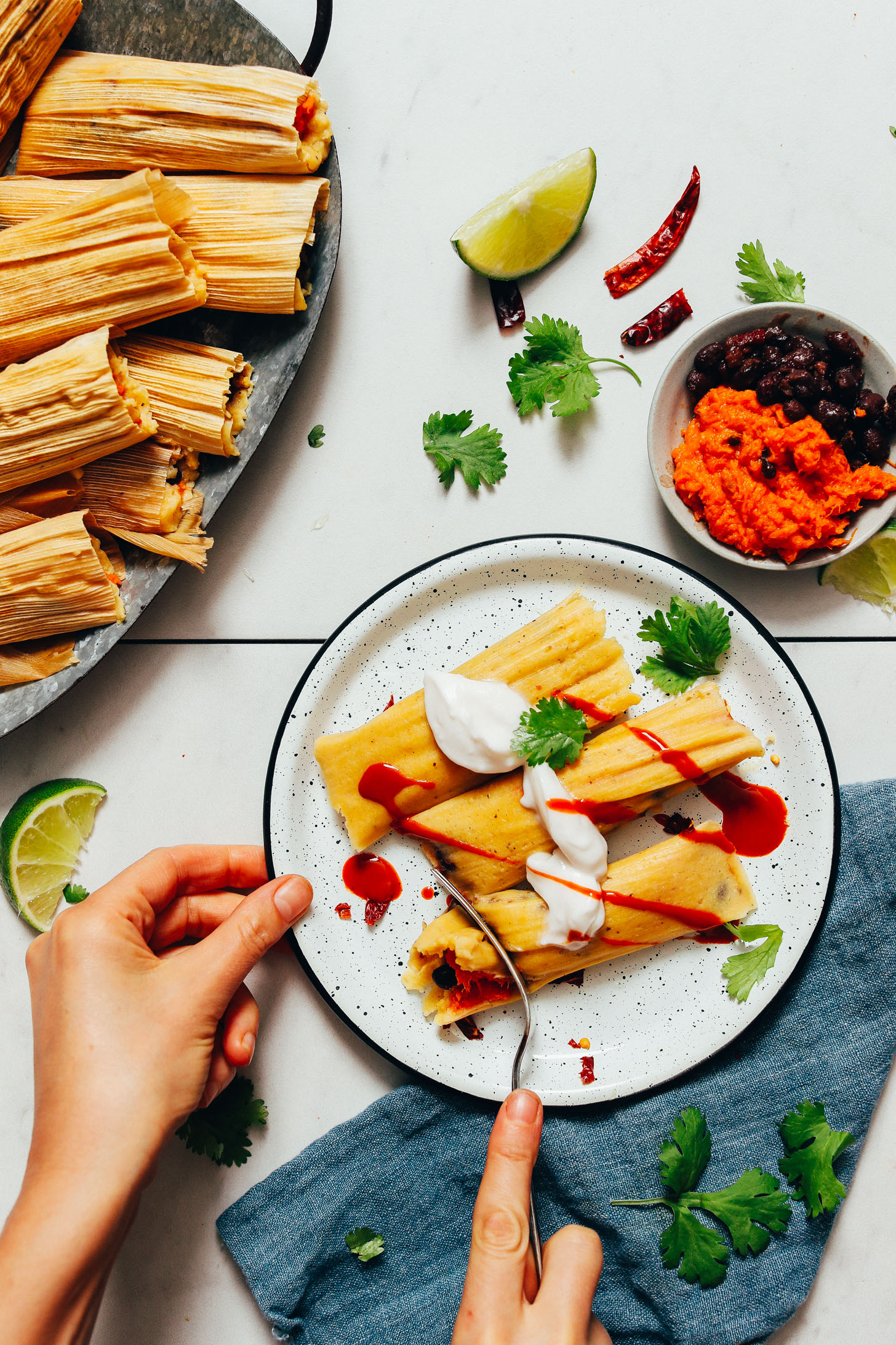 Using a fork to slice into a sweet potato black bean tamale