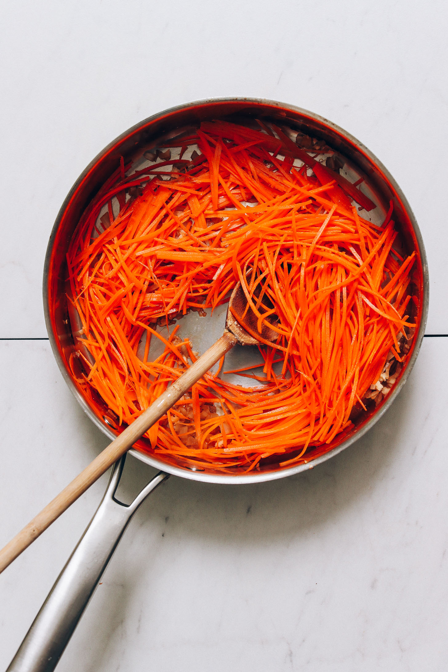 Skillet of shredded carrots and sautéed onions