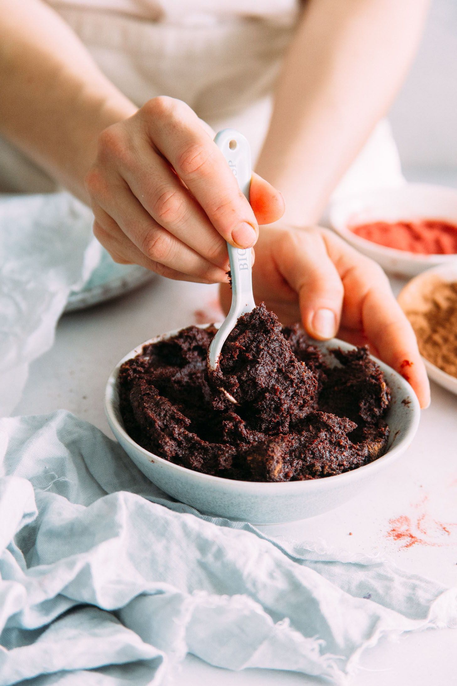 Spoon in a bowl of no bake red velvet cake bites dough