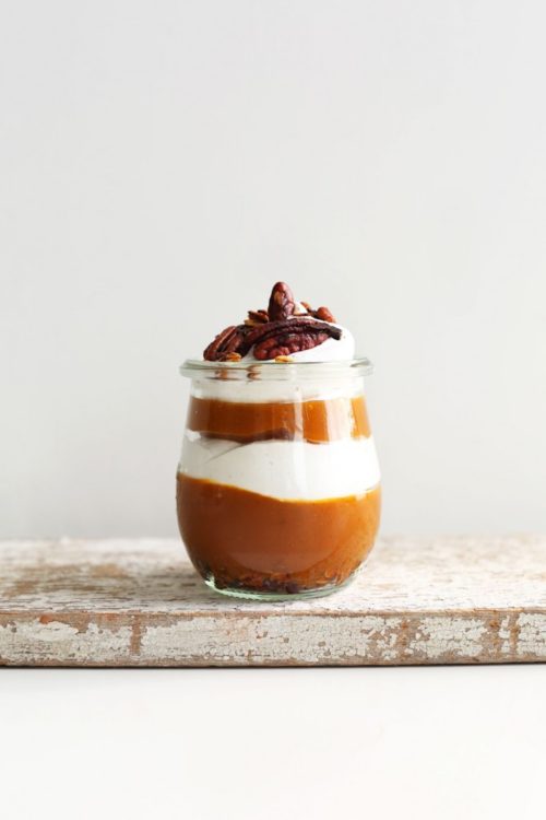 Distressed wood board with a small jar of our Pumpkin Pie Parfait recipe