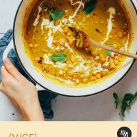 Hands holding the sides of a pot of our Curried Chickpea Soup recipe