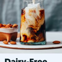 Pouring homemade vegan coffee creamer into an iced coffee