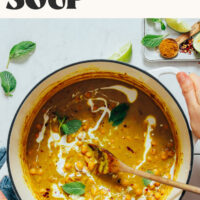 Holding the sides of a Dutch oven filled with our curried chickpea soup recipe
