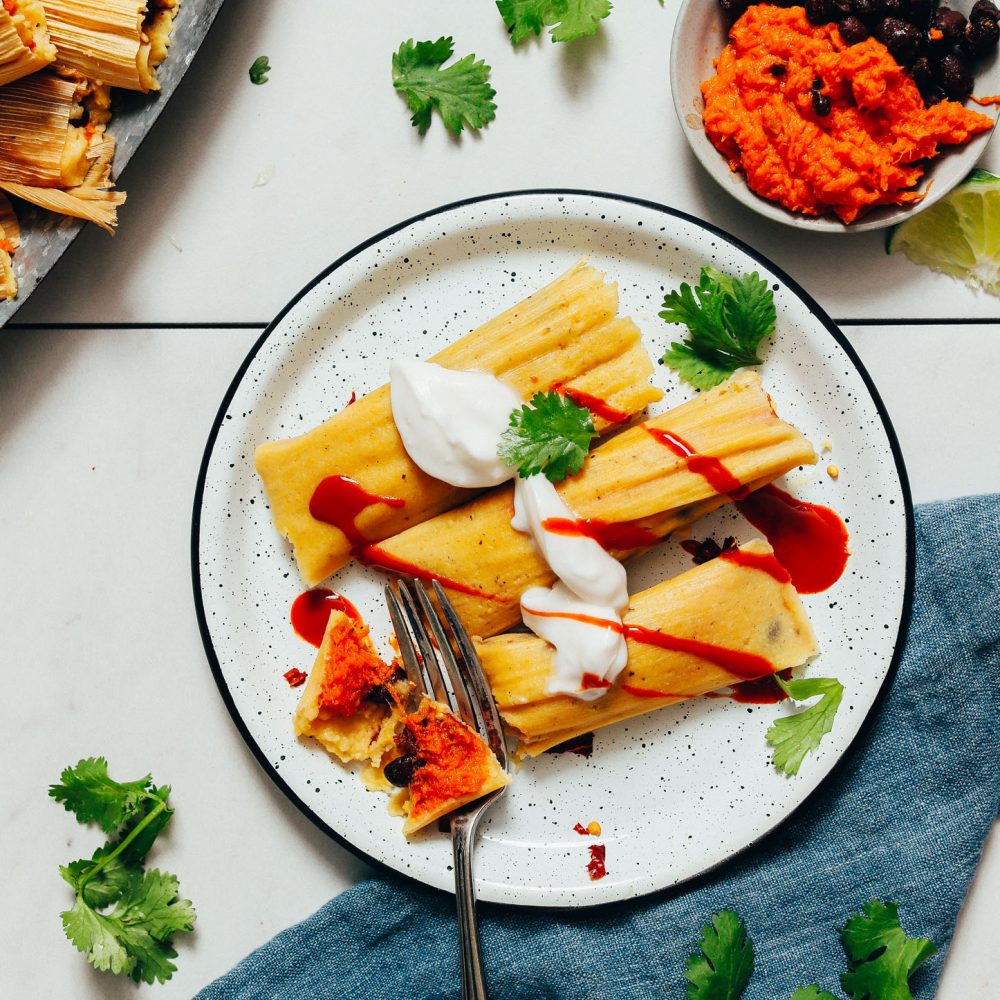 Fork cutting into a bite of Sweet Potato Black Bean Tamales