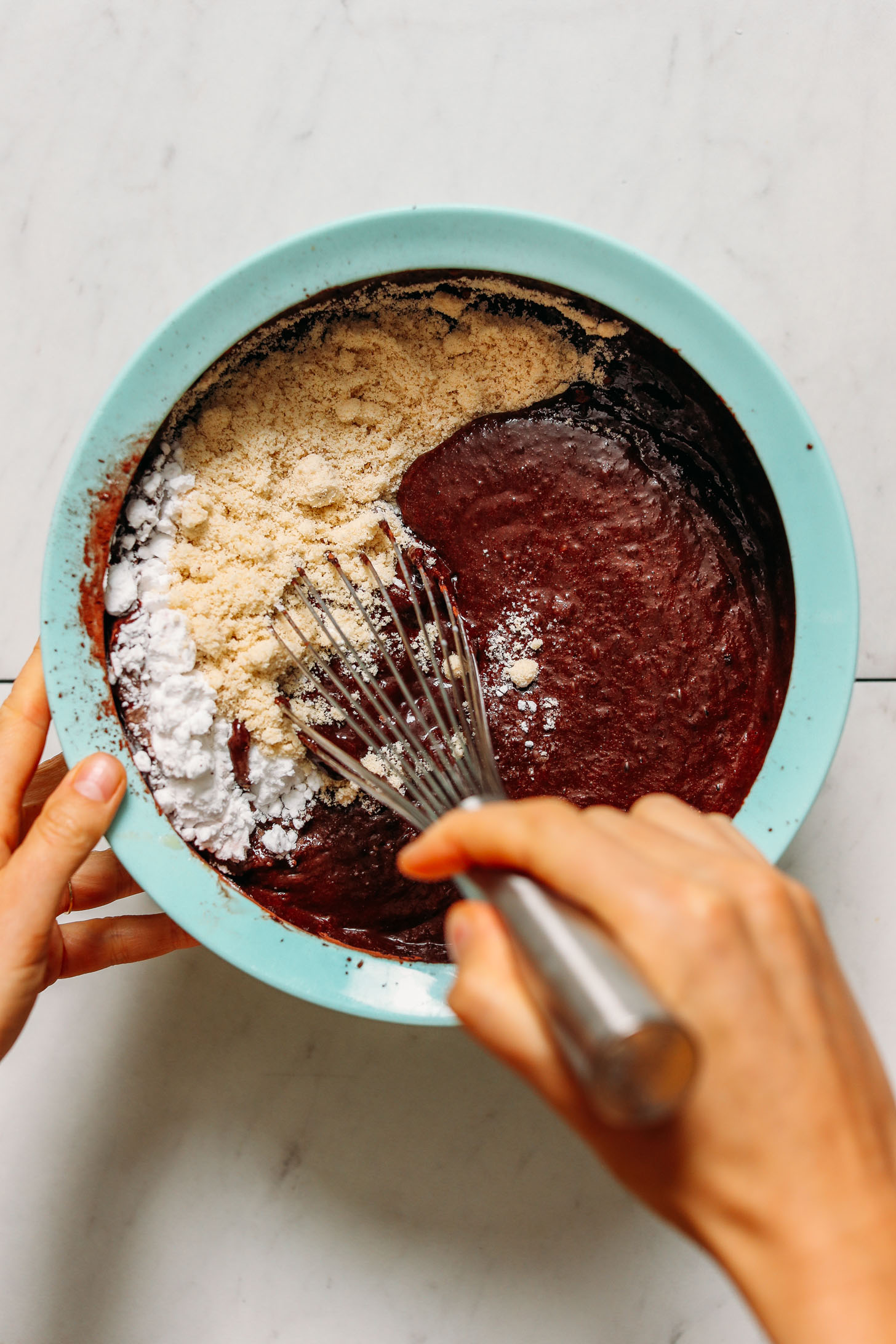 Whisking dry ingredients into wet ingredients with a whisk