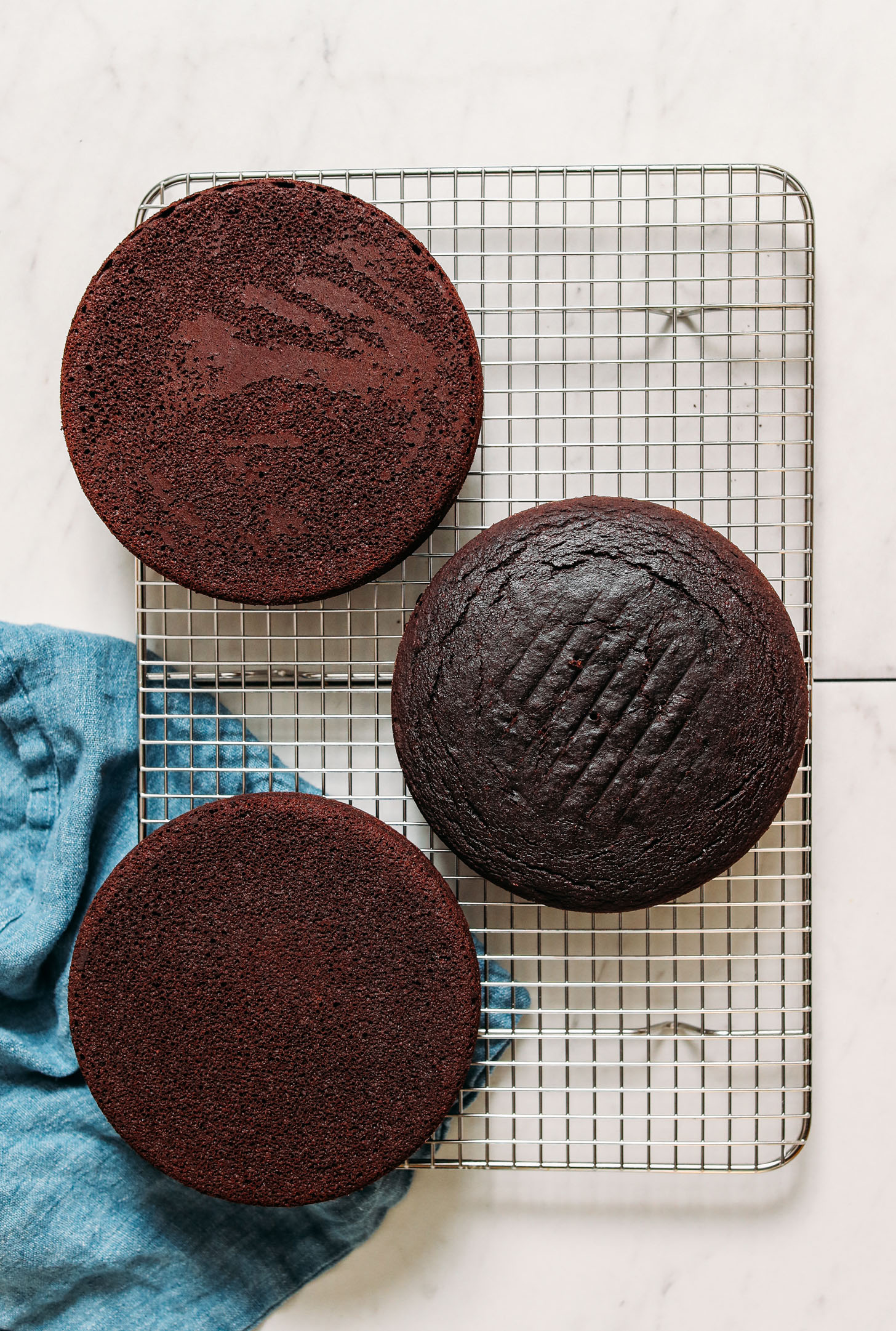 Three rounds of Vegan Gluten Free Chocolate Cake on a cooling rack