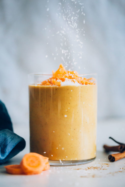 Sprinkling shredded coconut onto our Creamy Carrot Cake Smoothie