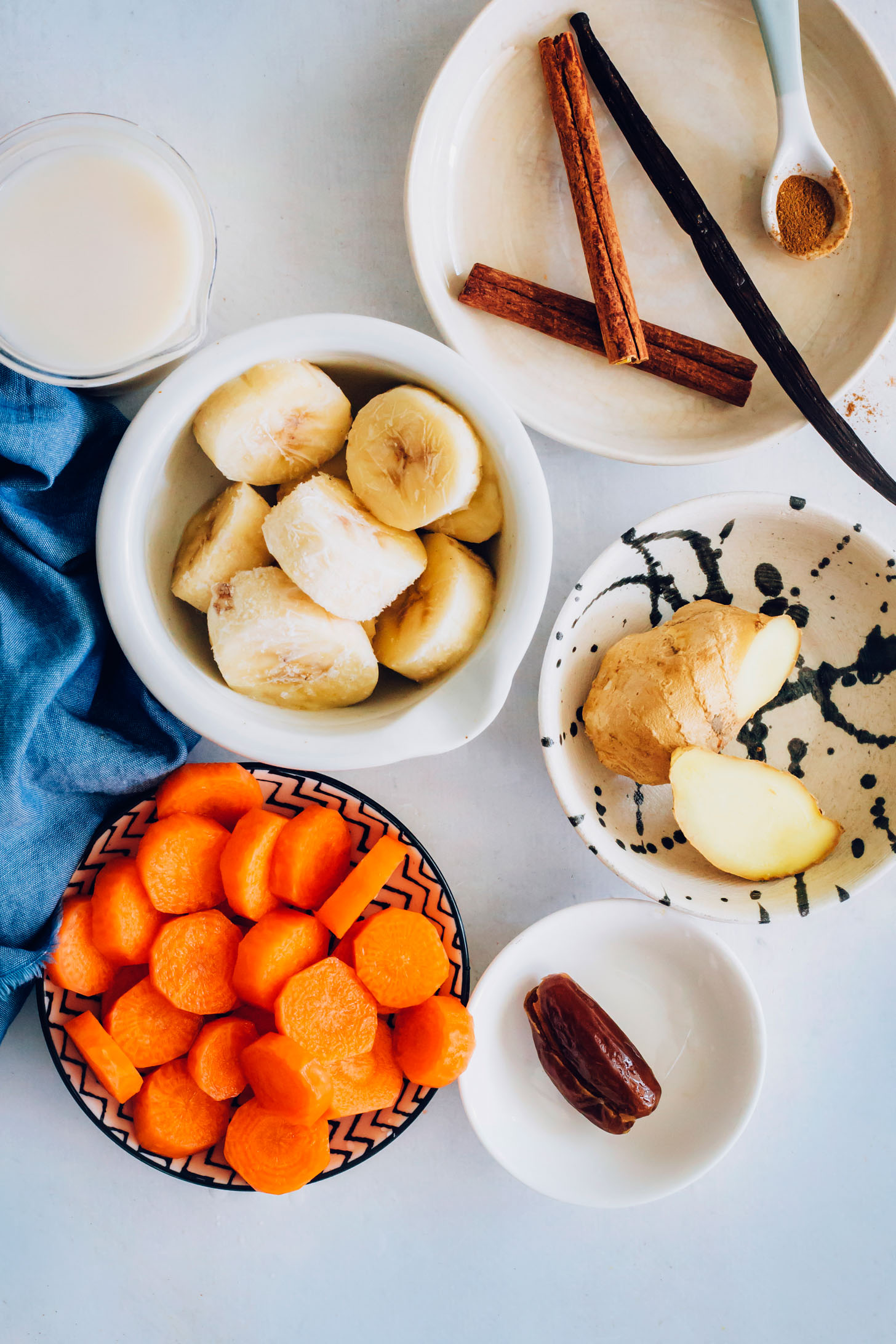 Cinnamon sticks, vanilla bean, ginger, date, sliced banana, carrots, and dairy-free milk