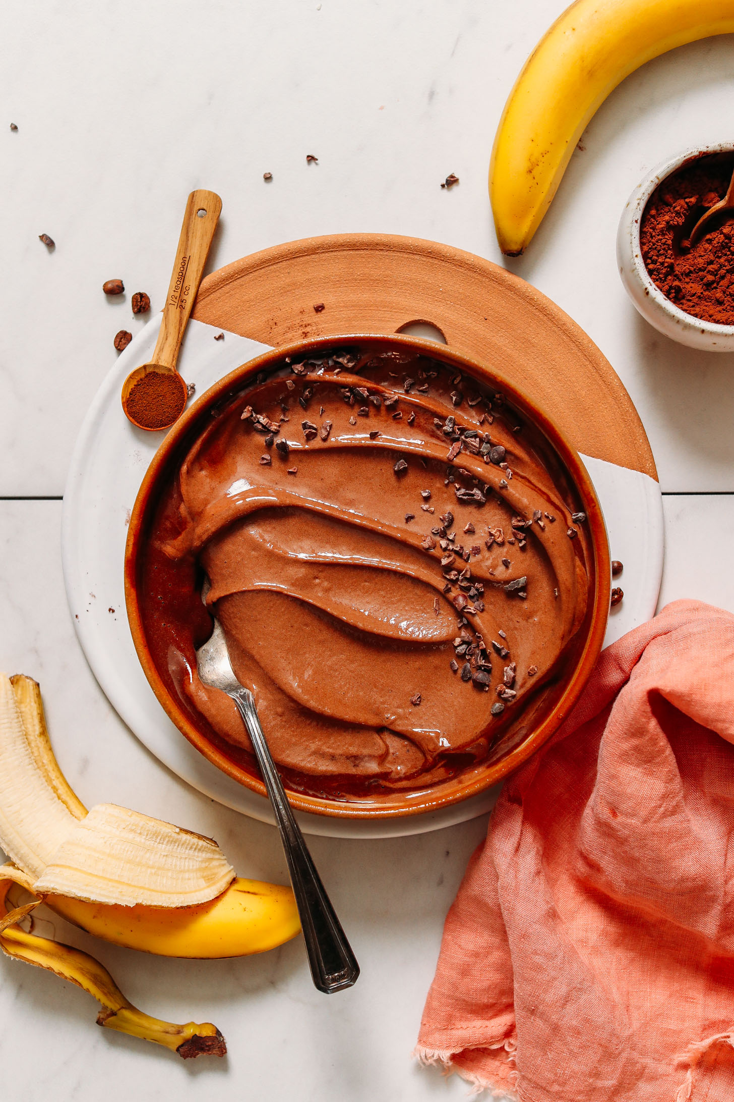 Bananas, dandy blend, and cacao powder around a bowl of Coffee Banana Chocolate Ice Cream