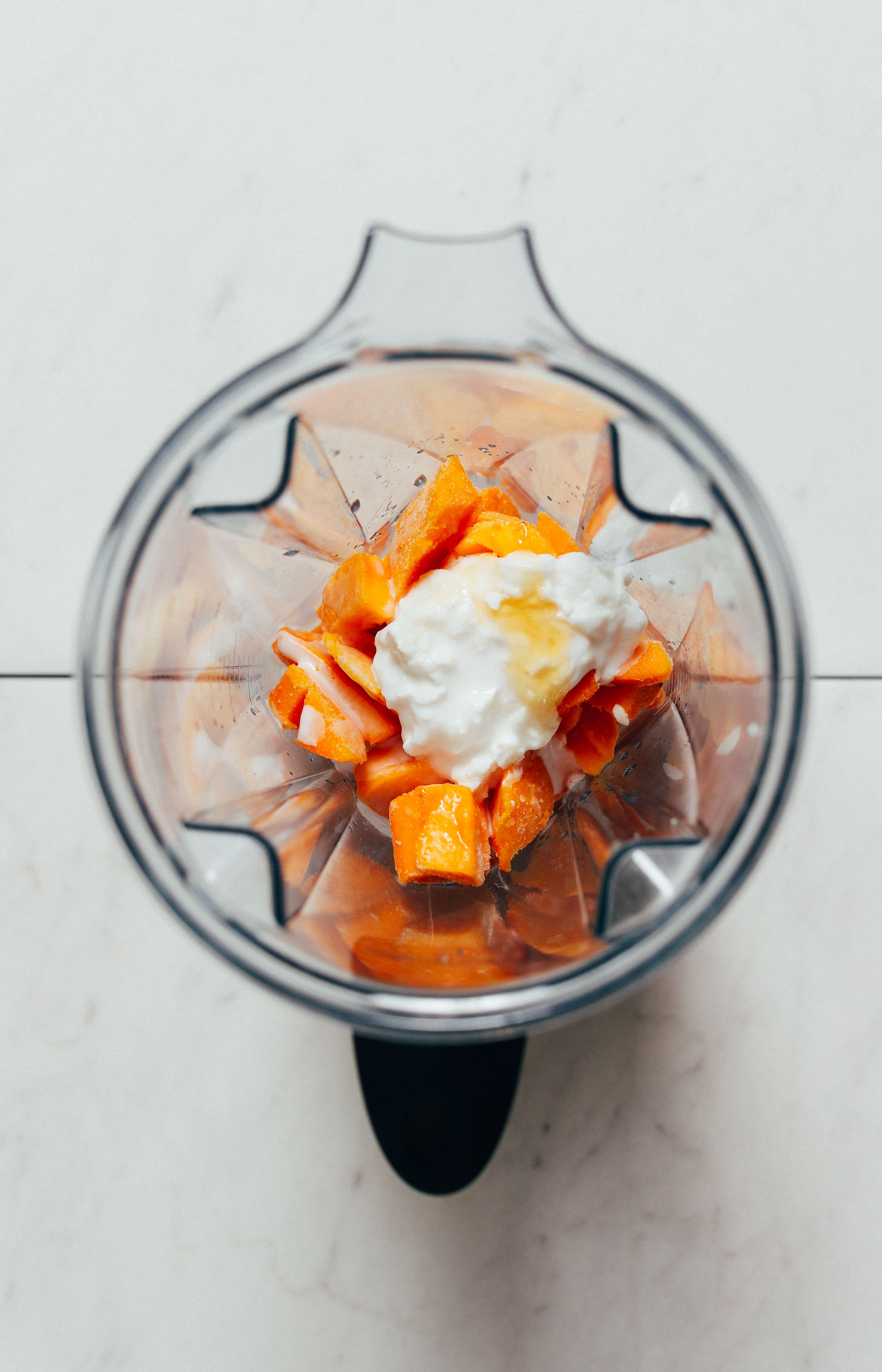 Blender of frozen mango, coconut yogurt, honey, lime juice, and coconut milk