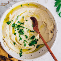 Bowl of fluffy vegan ricotta cheese topped with fresh parsley
