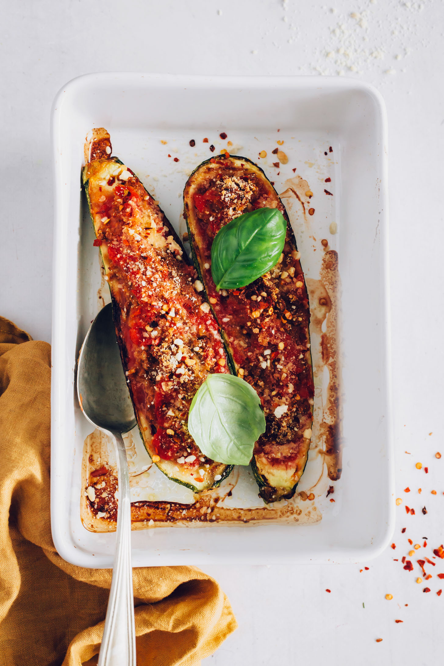 Vintage spoon resting in a pan of Vegan Zucchini Boats