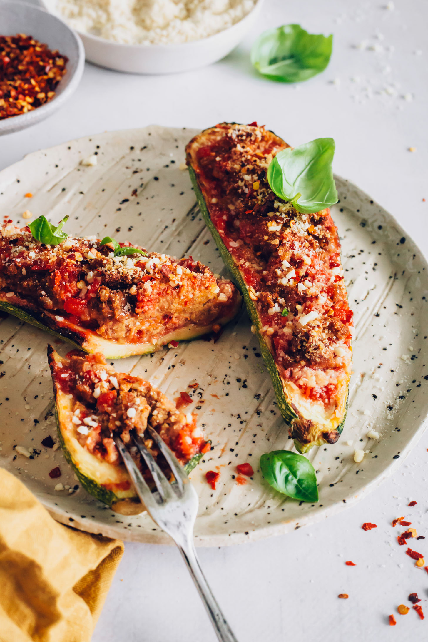 Fork spearing a halved Italian-Inspired zucchini boat