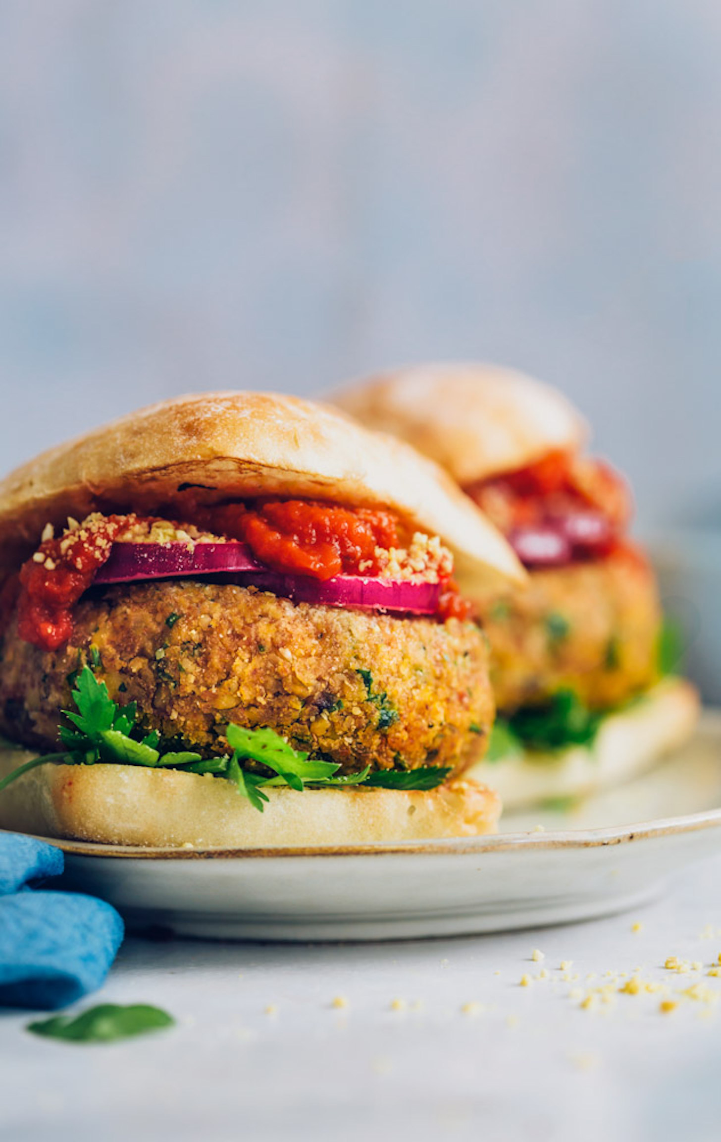 Plate of Vegan Pizza Burgers with marinara, red onion, and parsley