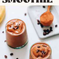 Two small glasses of our coffee chocolate smoothie topped with cacao nibs