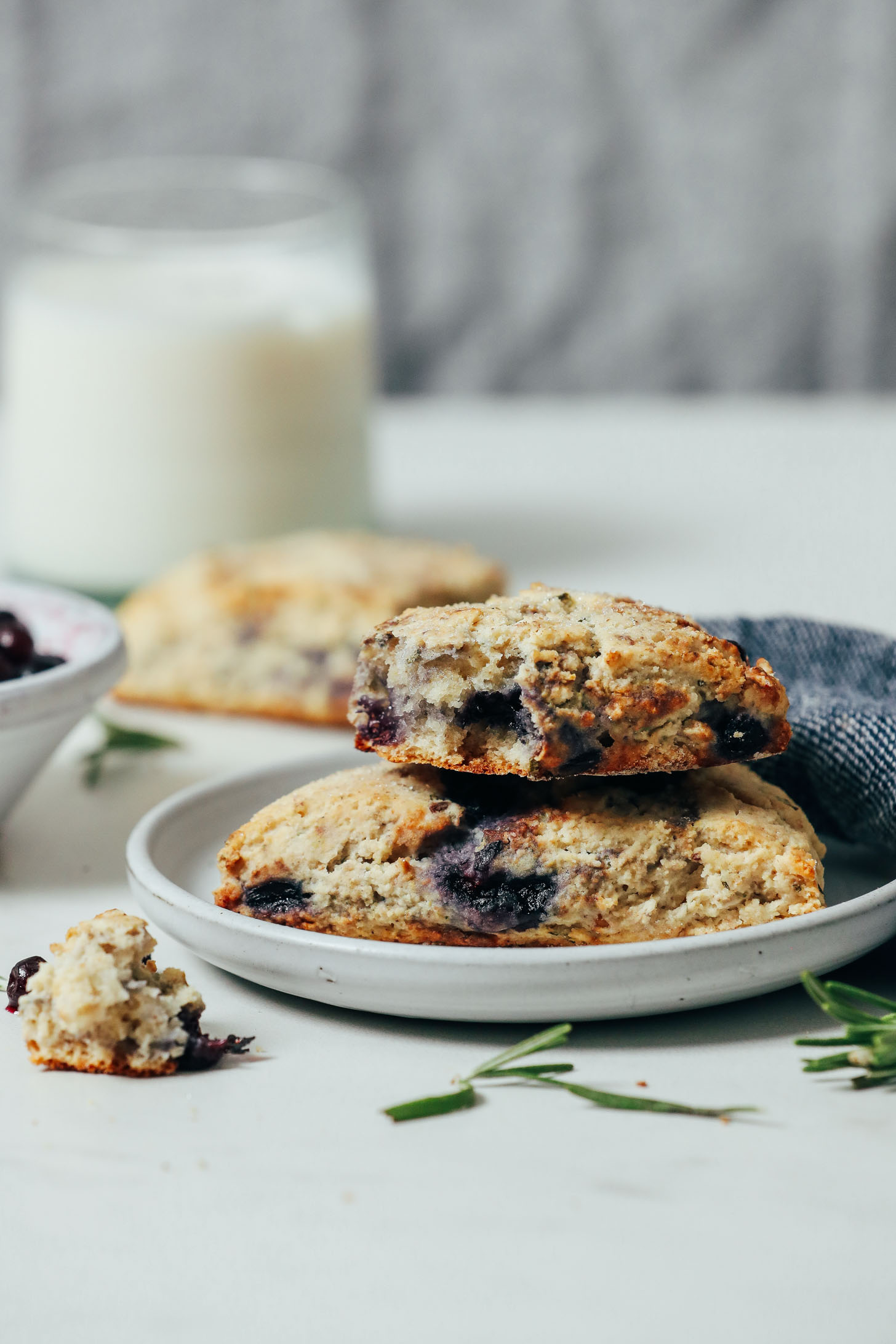 Small plate of Gluten Free Blueberry Scones beside a glass of almond milk