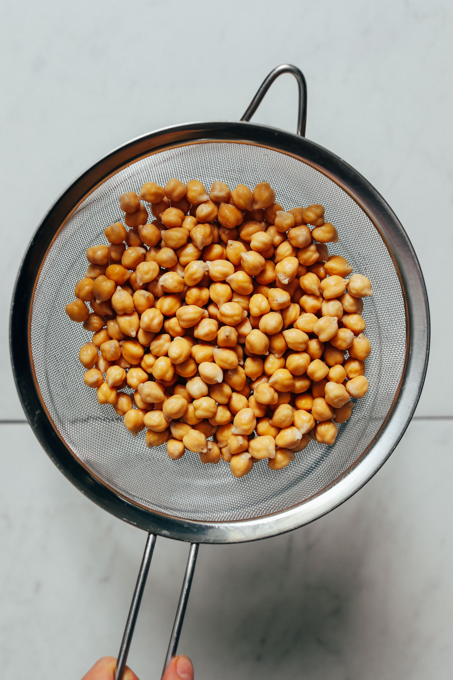 Soaked chickpeas in a fine mesh strainer
