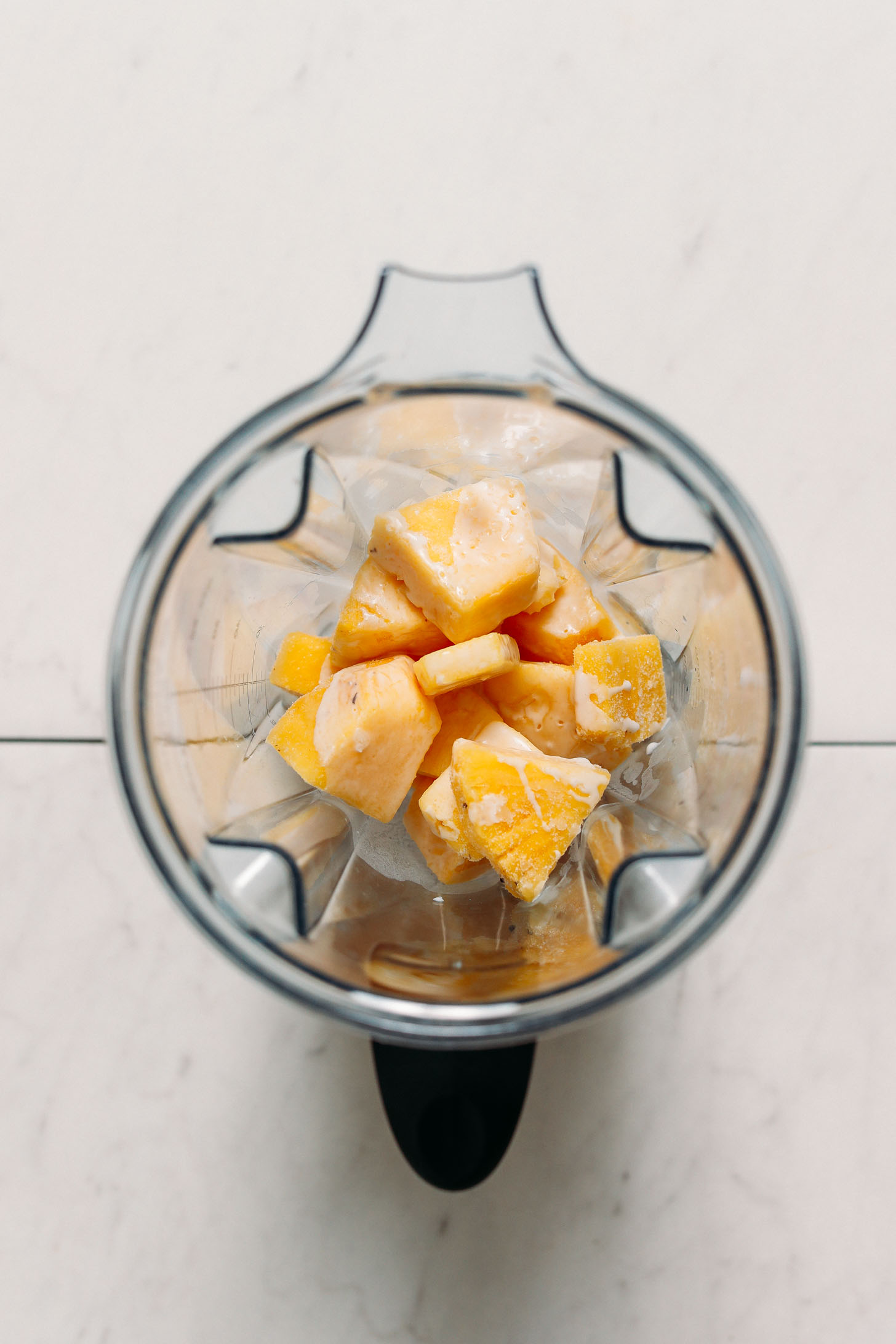 Frozen pineapple chunks and coconut milk for making a piña colada