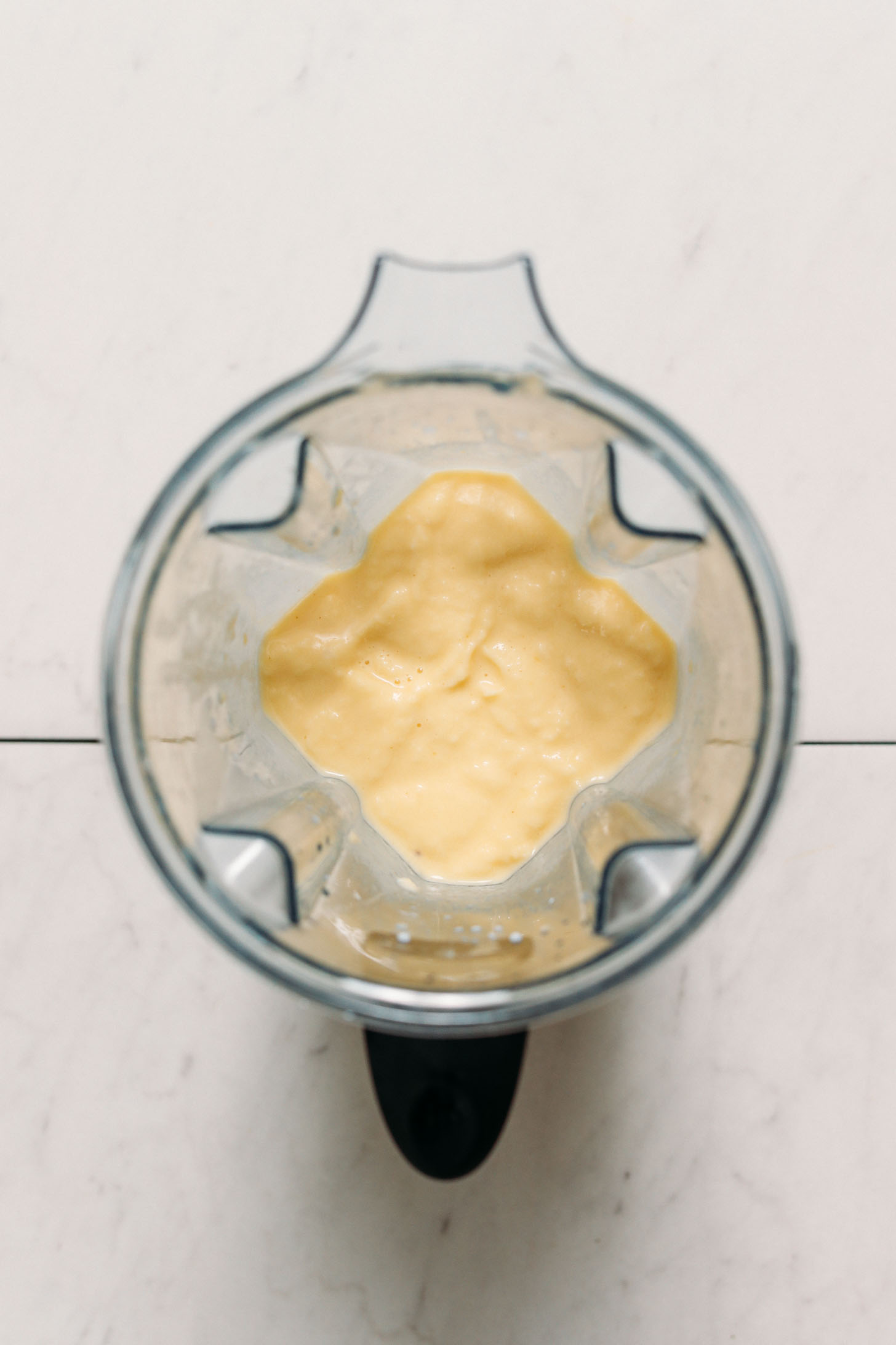 Blender of creamy piña colada smoothie