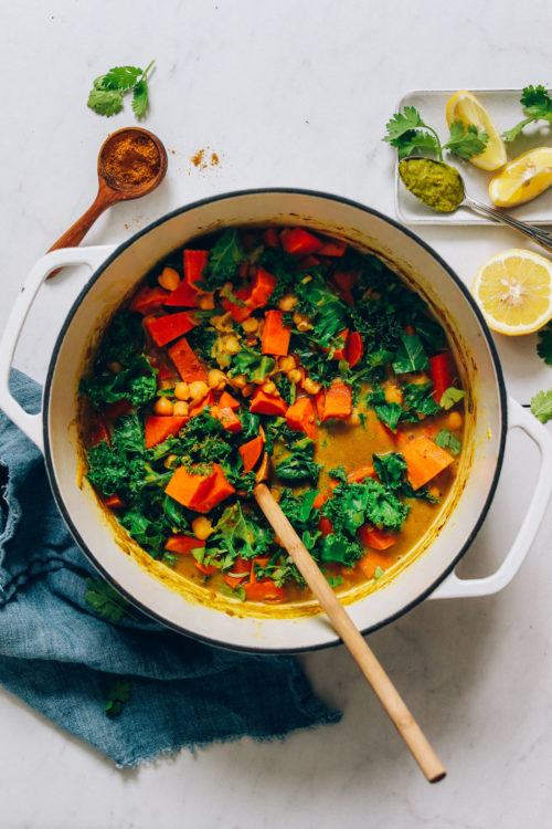 Wooden spoon in a pot of our Sweet Potato Chickpea Green Curry