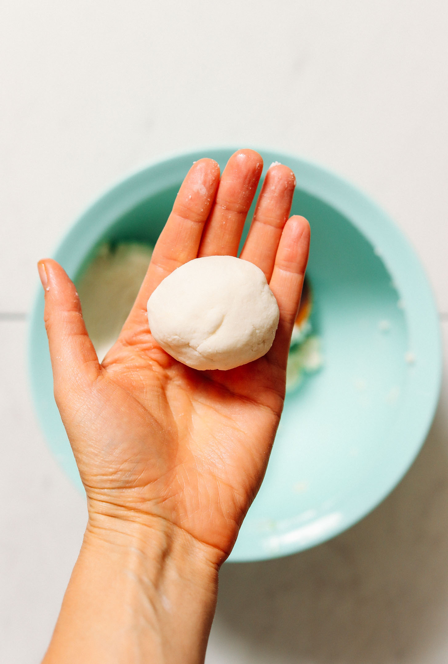 Holding a ball of gluten free naan dough