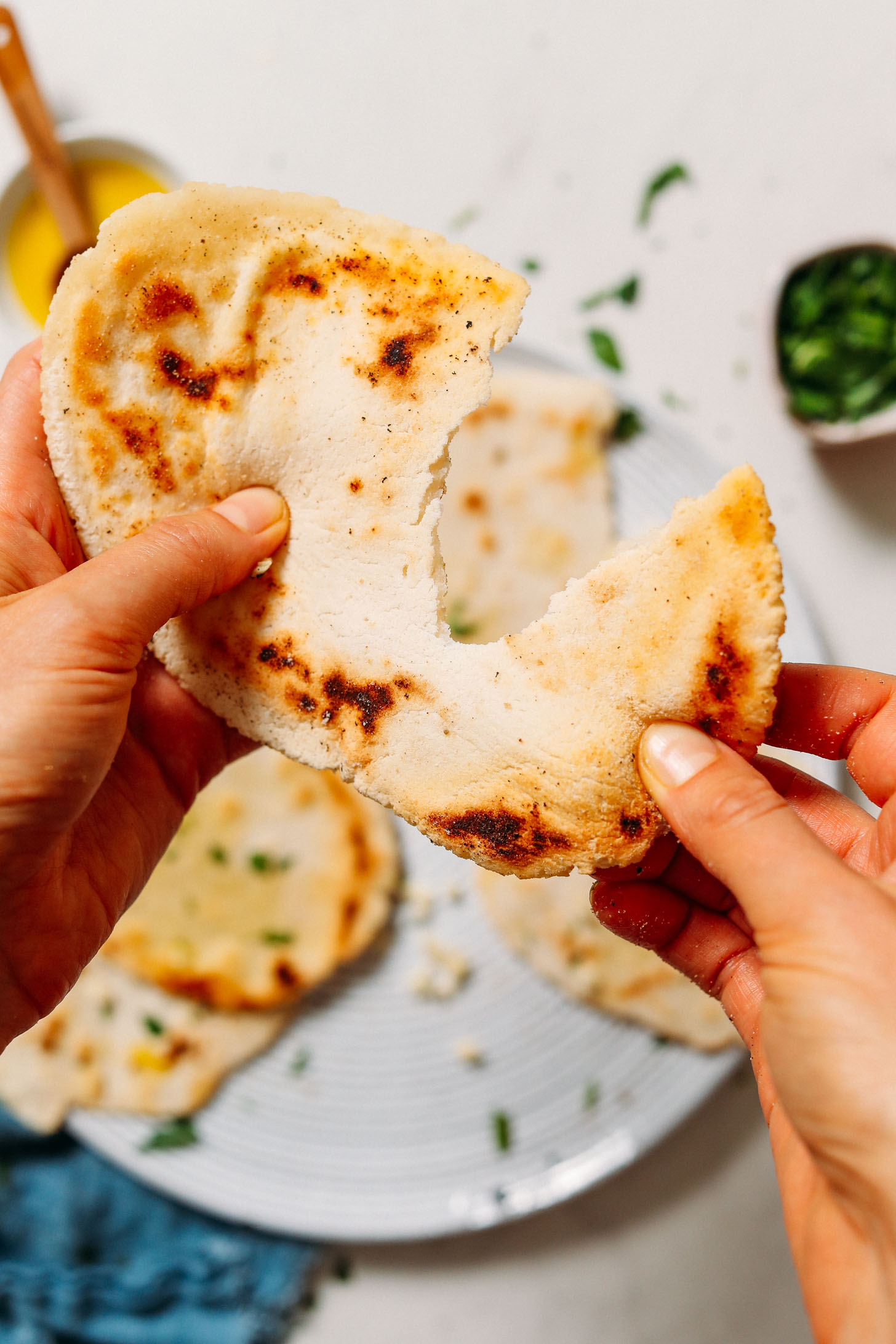Pulling apart a piece of stretchy gluten free naan bread