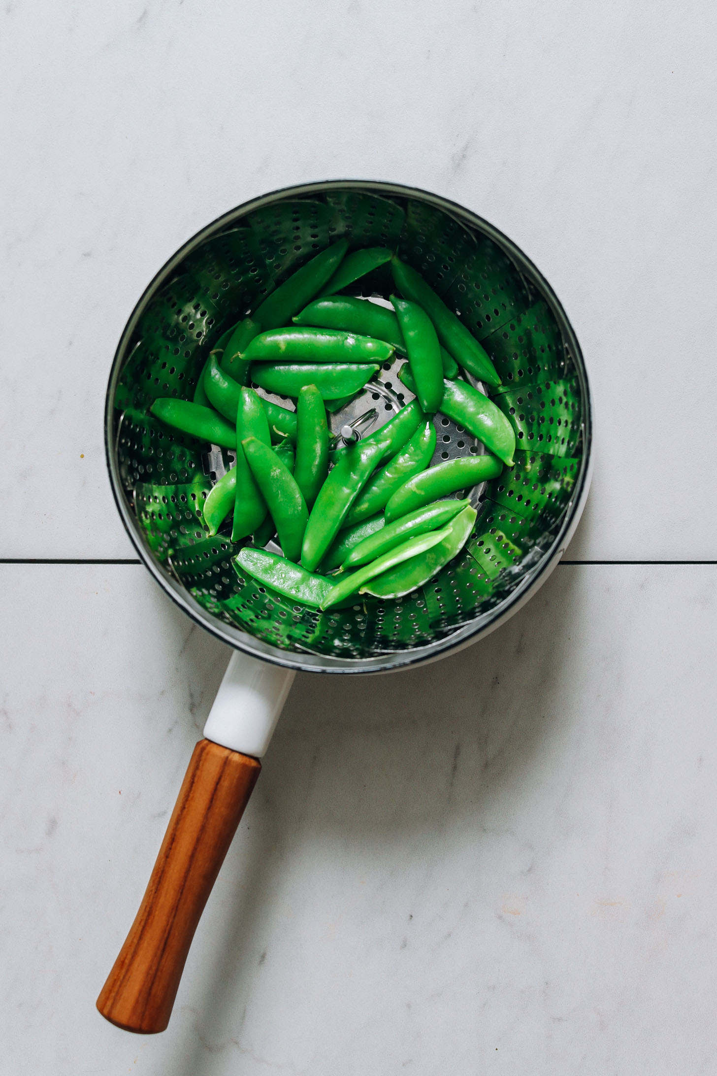 Steaming snow peas in a small saucepan
