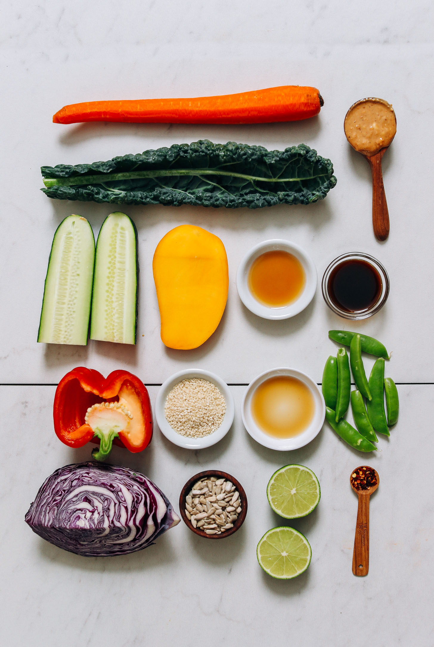 Carrot, kale, cucumber, mango, bell pepper, red cabbage, snow peas, lime, quinoa, nut butter, coconut aminos, maple syrup, and sesame oil