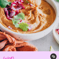 Spoon lifting a bite of vegan refried beans from a bowl