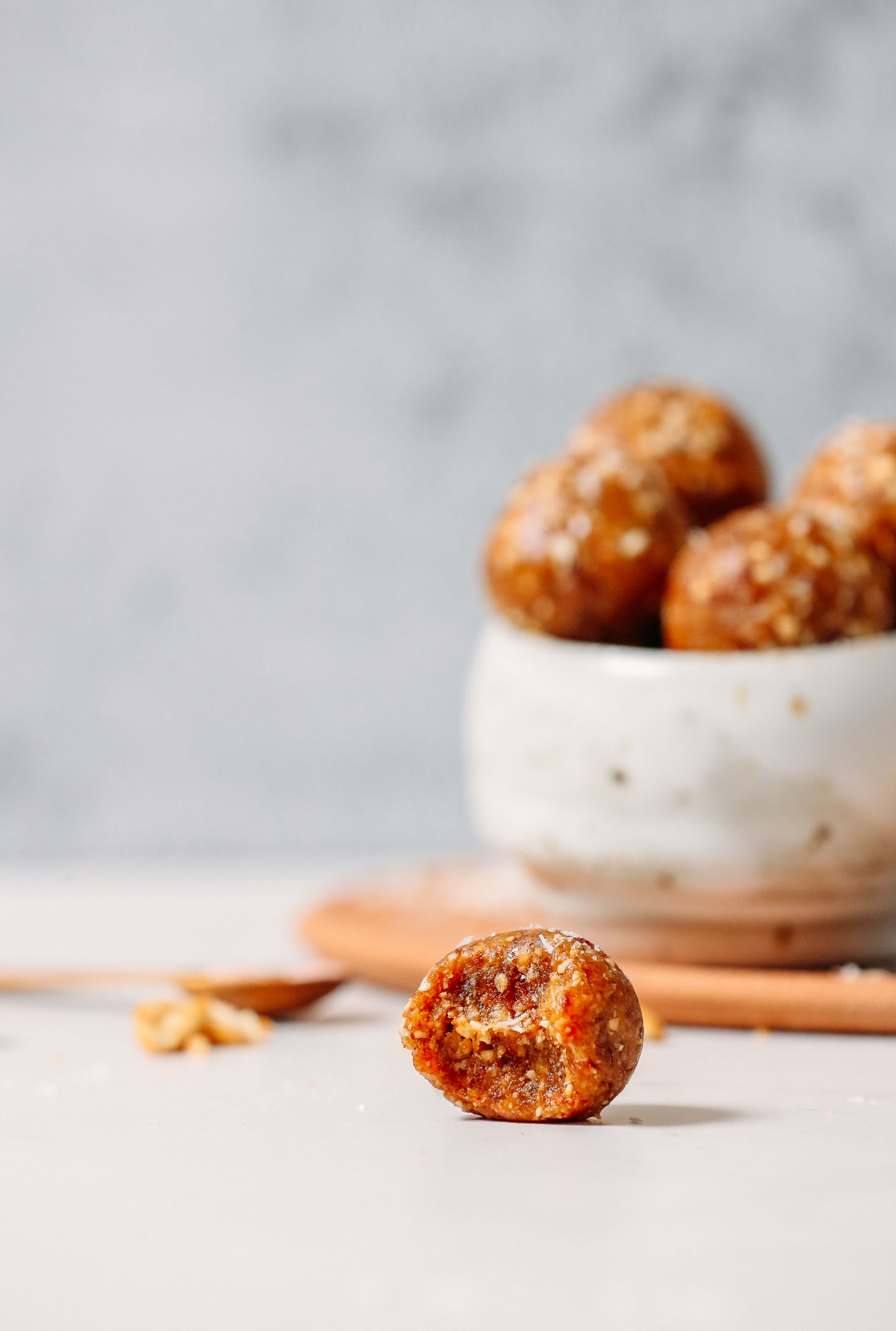 Salted Caramel Date Energy Bite sitting next to a bowl of more date bites