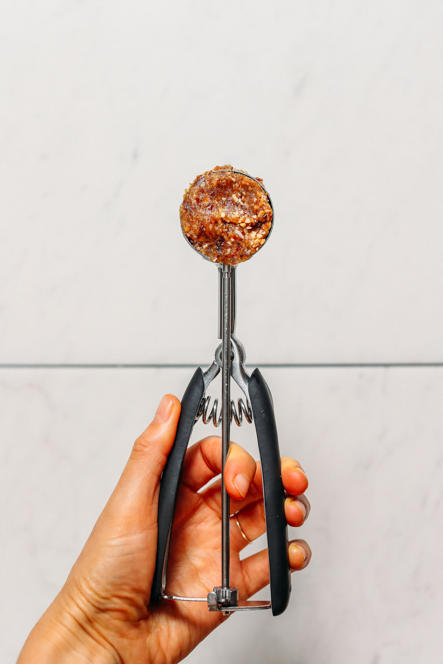 Salted Cashew Caramel Energy Bite dough in a small cookie scoop