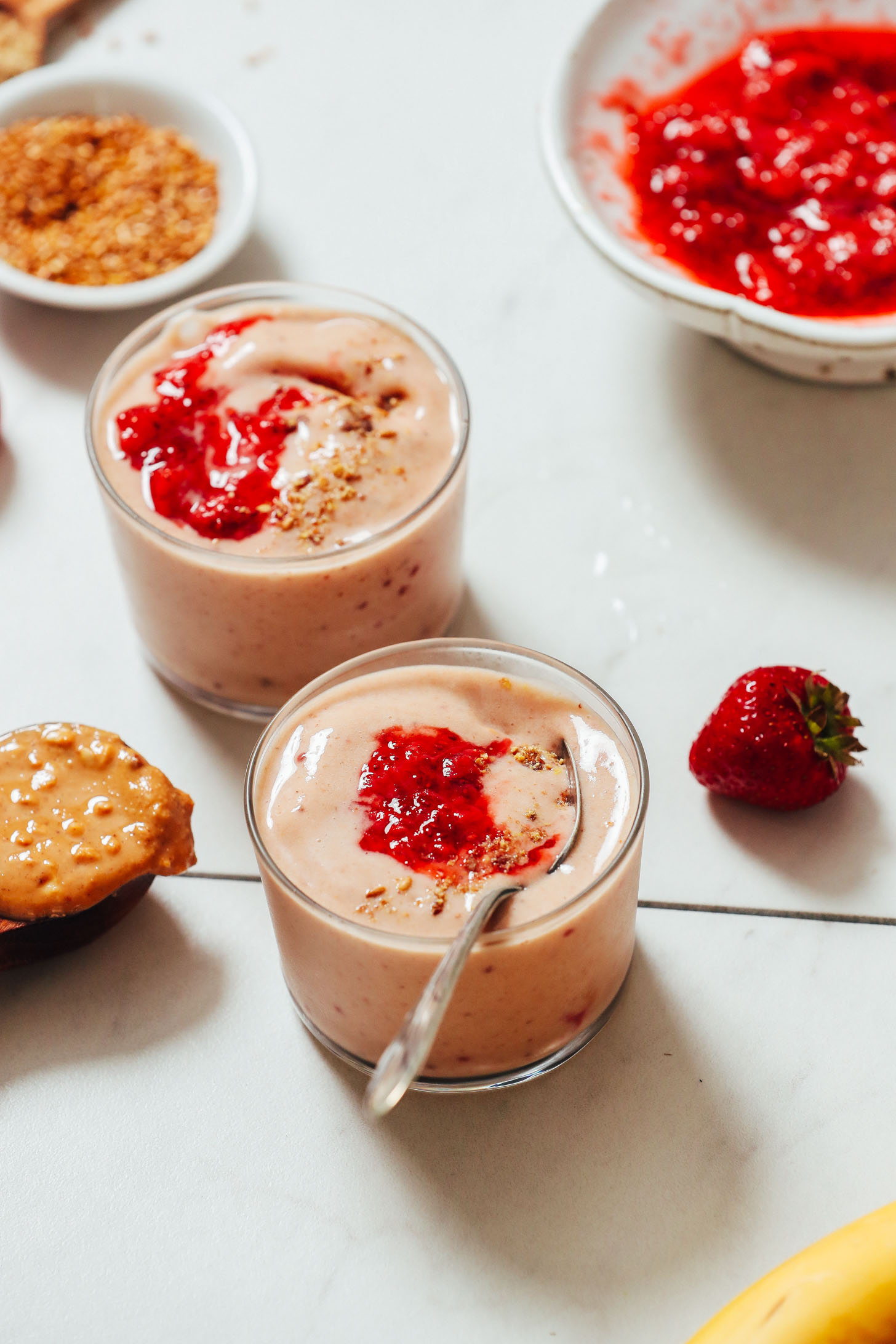 PB&J Smoothies in short glasses topped with strawberry compote and ground flax seeds