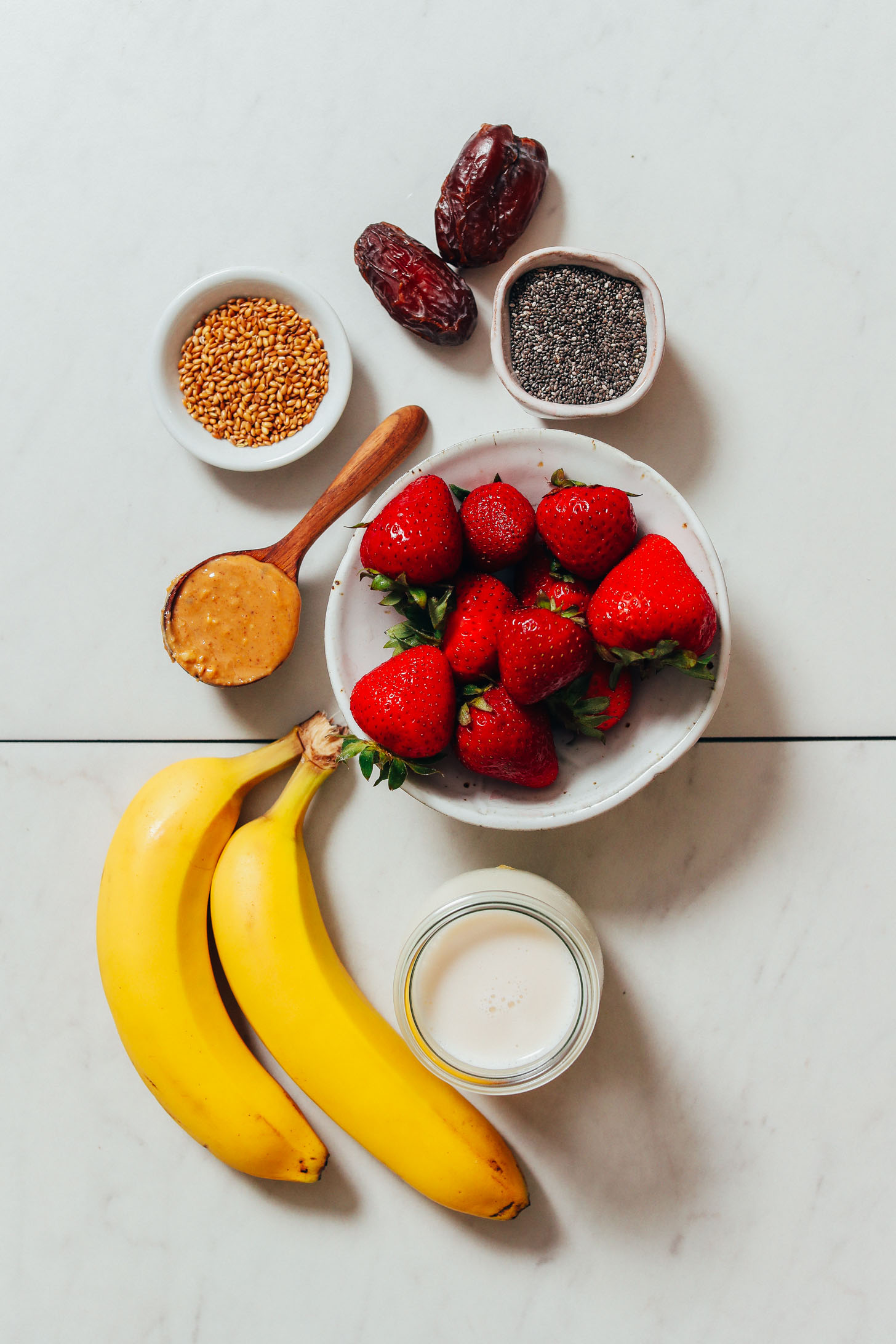 Dates, chia seeds, flax seeds, peanut butter, bananas, strawberries, and dairy-free milk