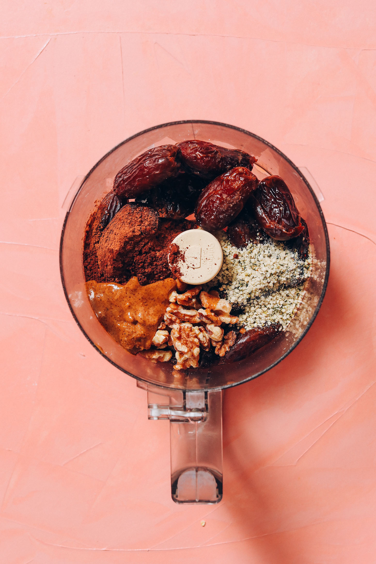 Food processor with dates, hemp seeds, walnuts, almond butter, and cacao